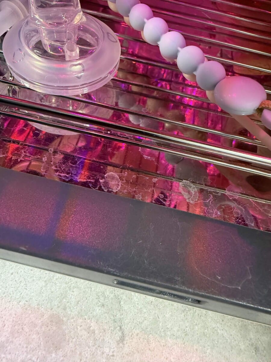젖병소독기 내부 철망 주변에 물때가 남아 있어 주기적 청소가 필요한 부분을 보여주는 사진